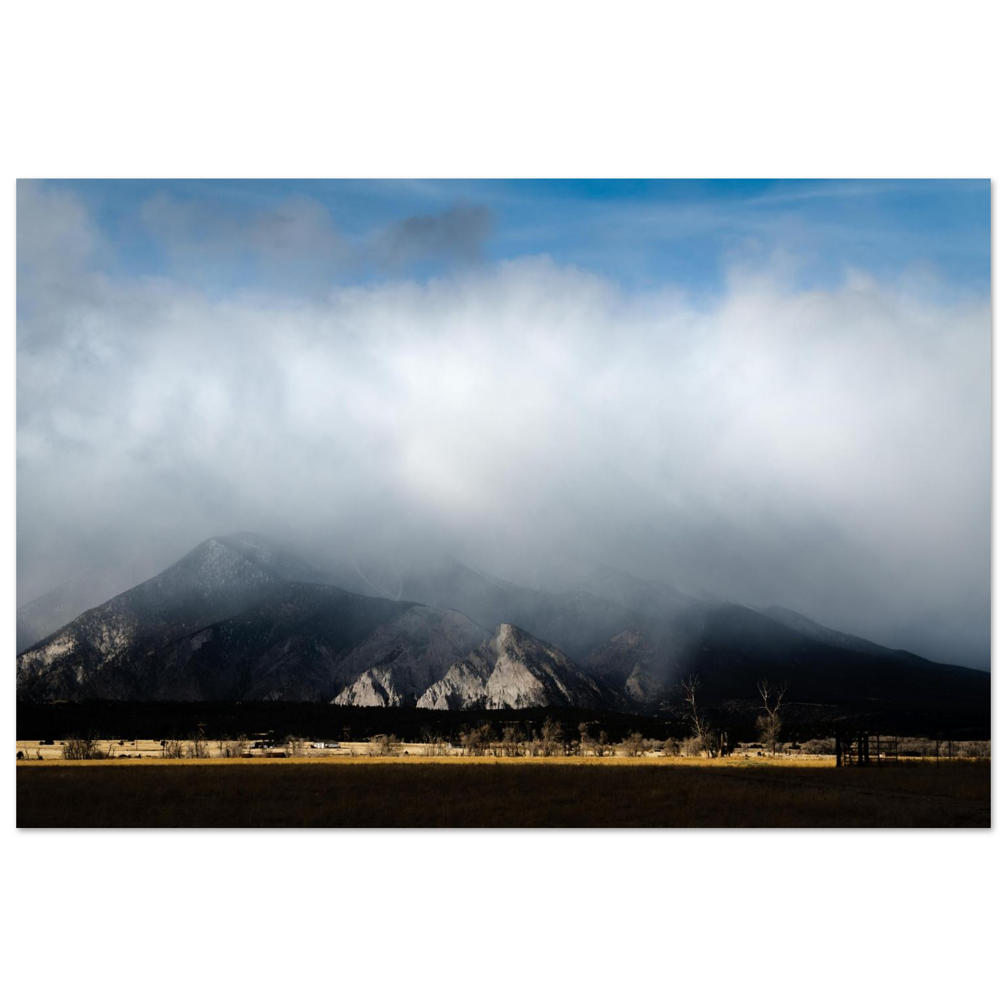 Mountain peak above clouds photography print with blue sky and golden sunlight, dramatic horizontal landscape wall art
