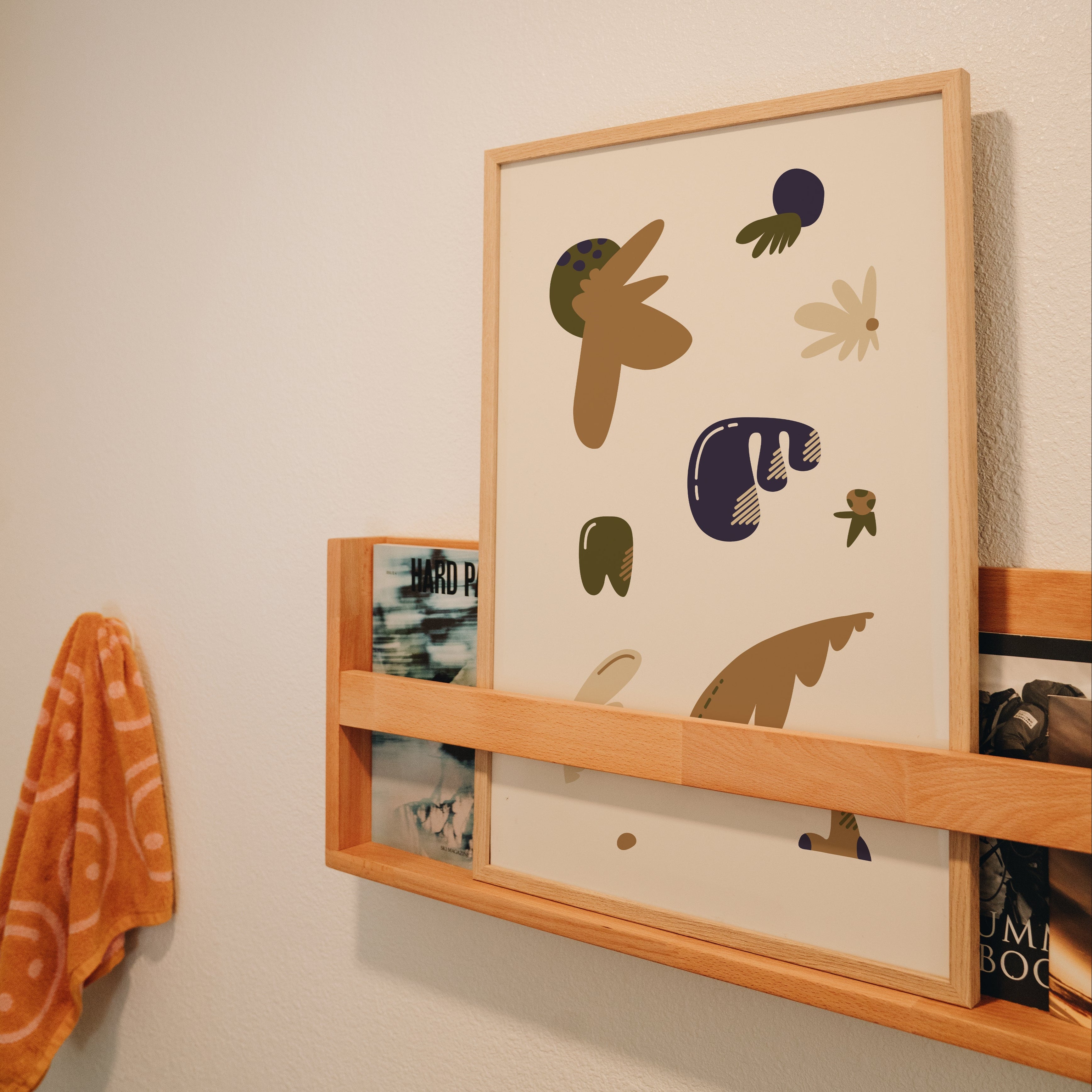 Brown Blob Fam whimsical print displayed in magazine rack, quirky wall art styling inspiration