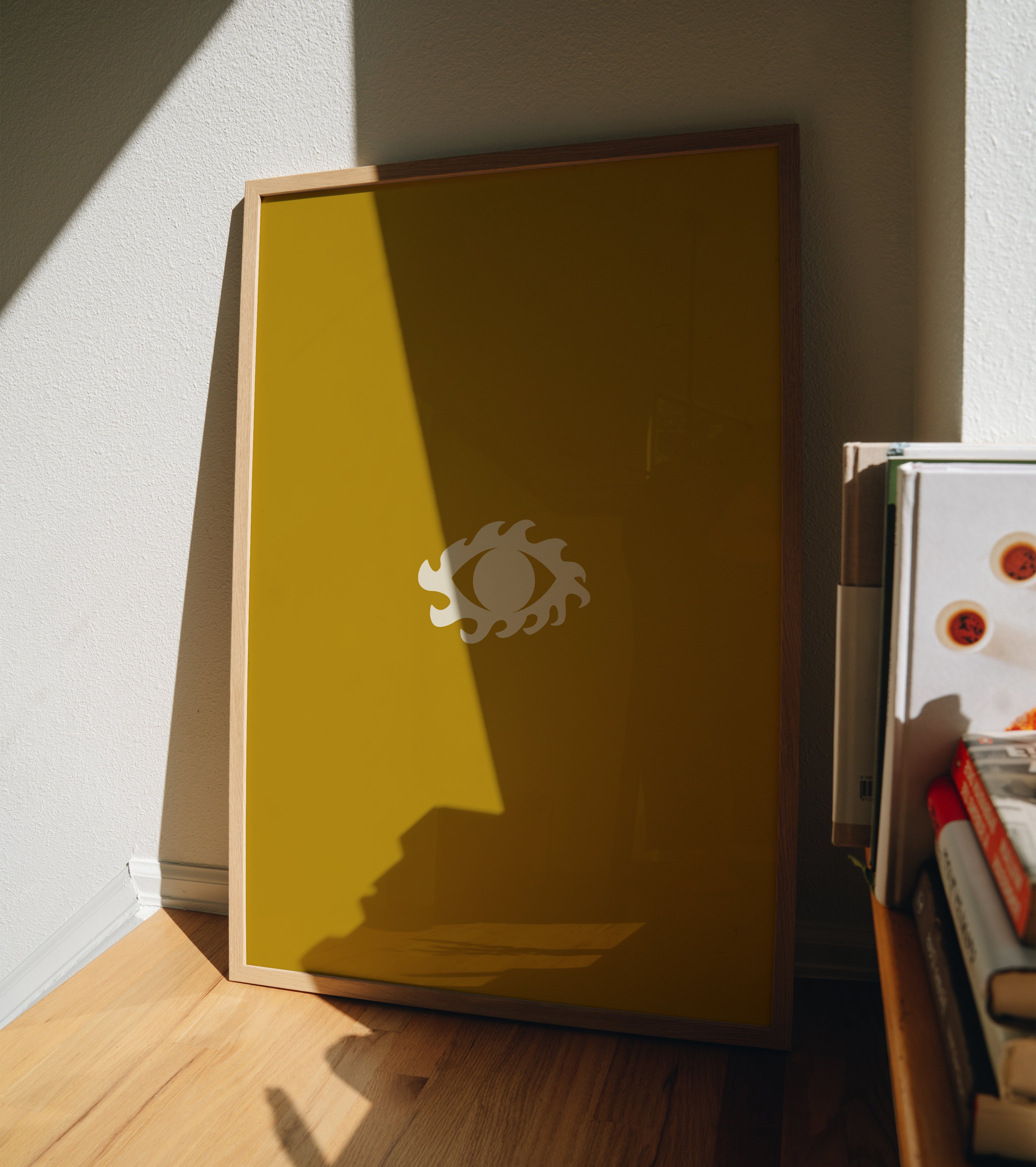 Golden Eye minimalist print in frame propped against wall near window with natural shadows, sunny wall art styling inspiration