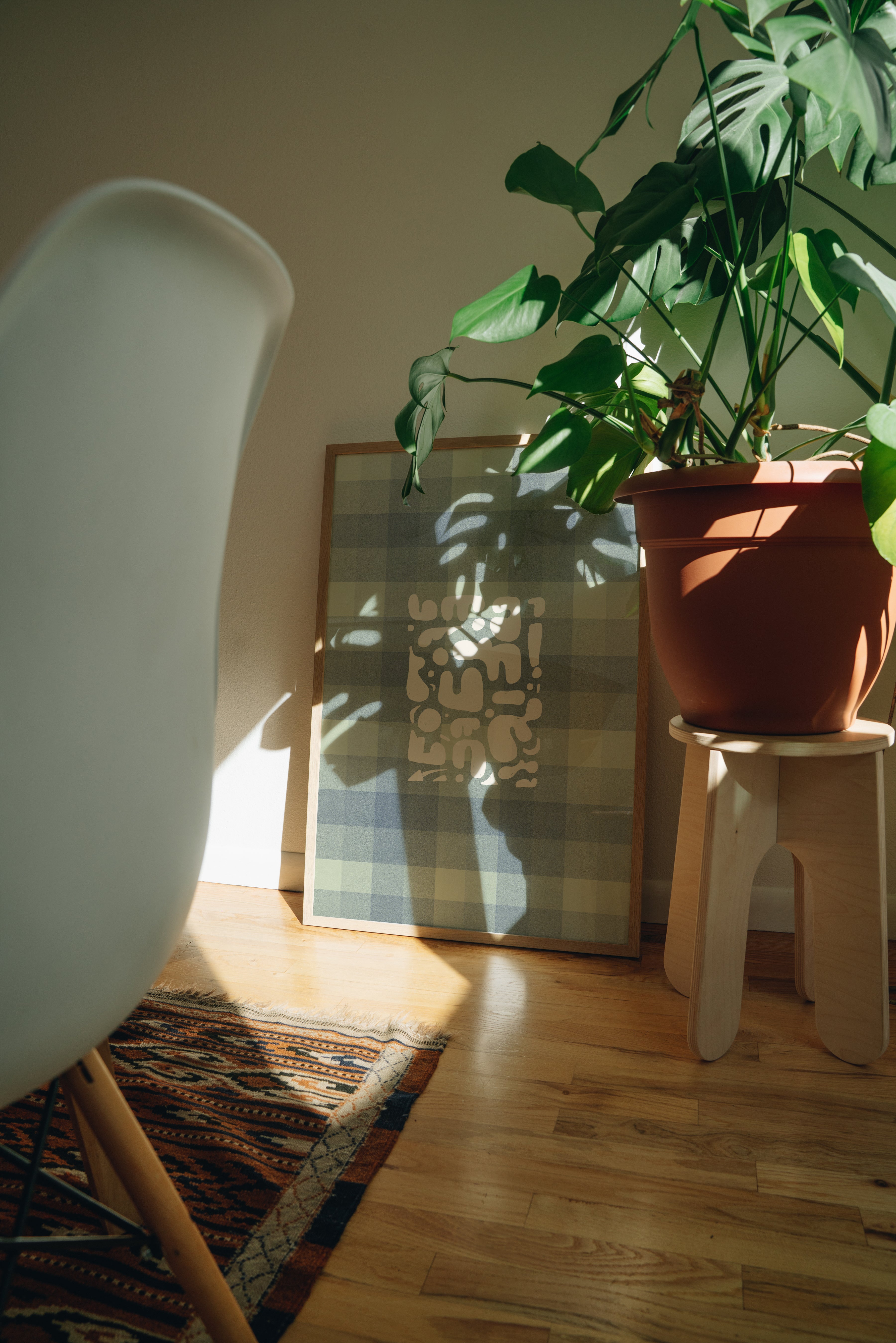 Table Talk vintage abstract print in large frame propped against kitchen wall behind plant, modern dining art styling inspiration